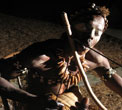 Un nganga, sorcier bwiti, joue du mugongo, l'arc en bouche